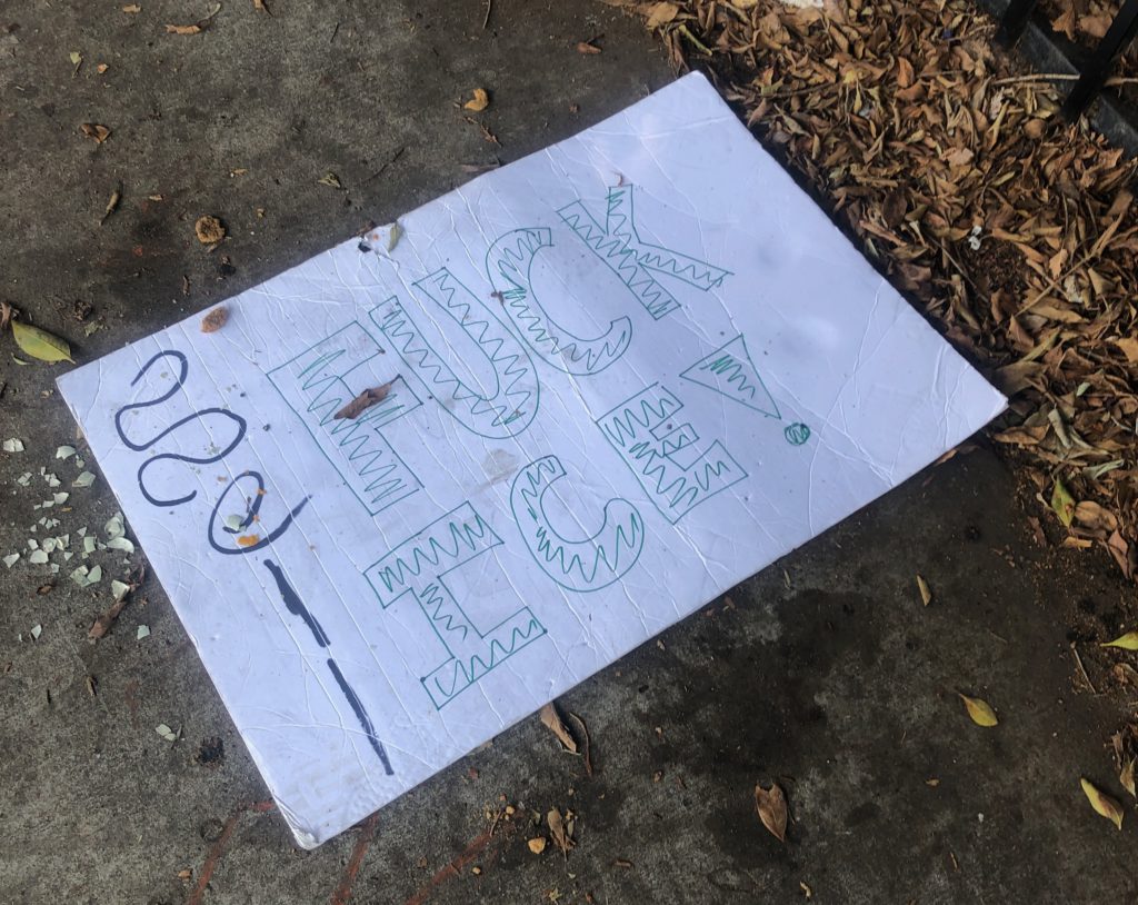 Protest sign that reads "Fuck ICE" on a sidewalk in downtown Los Angeles.