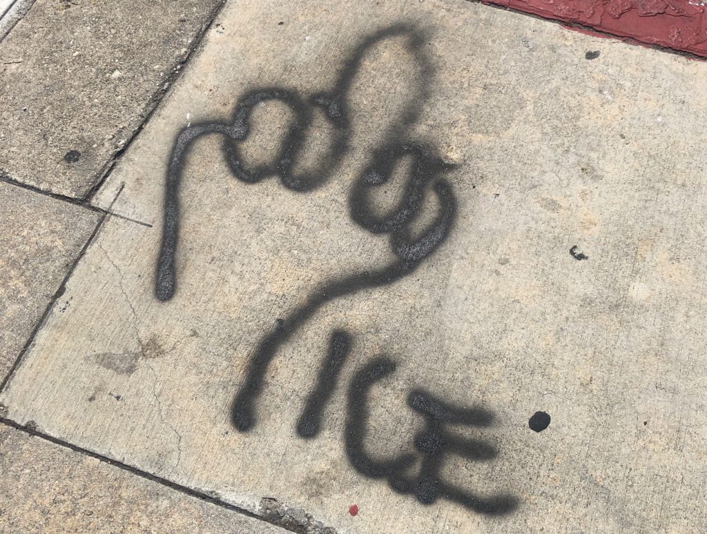 Graffiti in downtown Los Angeles of a middle finger and the word Ice