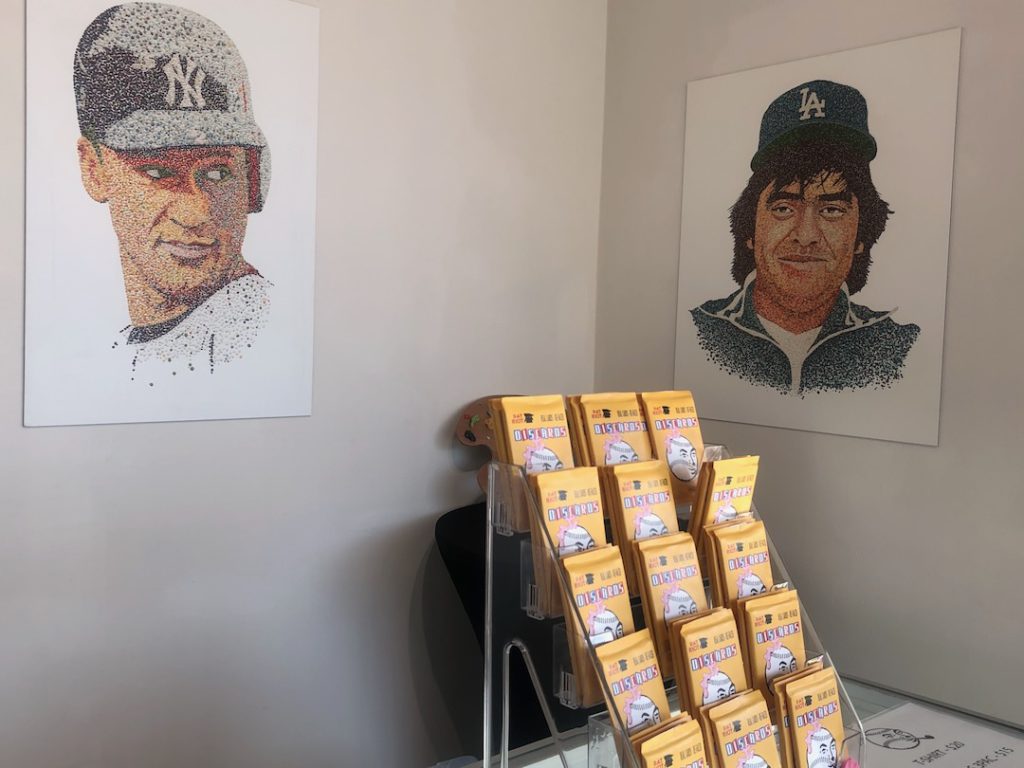 Prints of Pat Riot's bubblegum portraits of Derek Jeter and Fernando Valenzuela above a display of Discards at Eastern Projects (Photo: Liz Ohanesian)