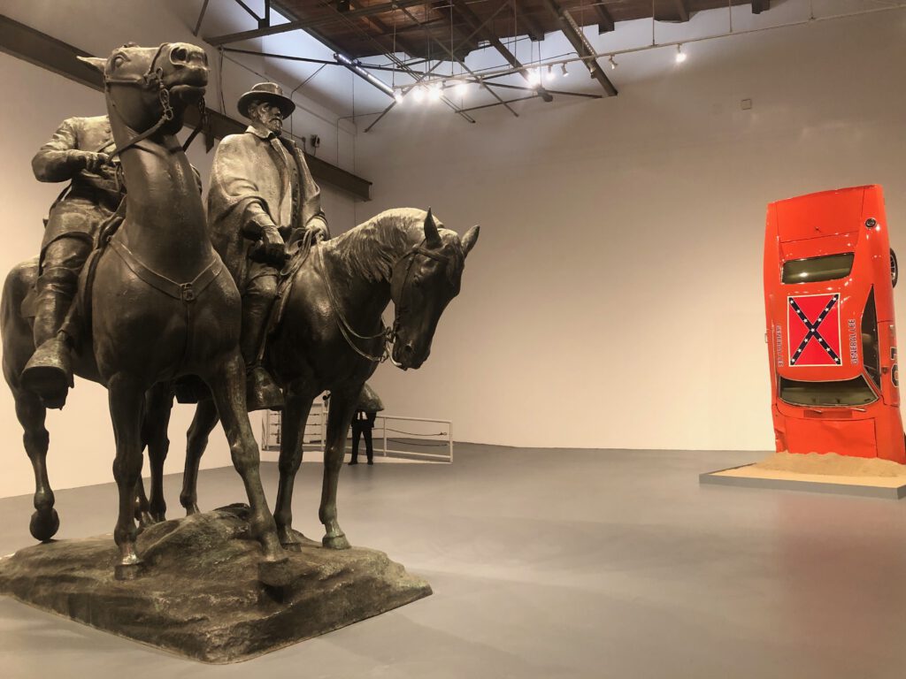 Statue of Robert E. Lee and Stonewall Jackson in the foreground, A Suspension of Hostilities by Hank Willis Thomas in the background at Monuments Geffen Contemporary at MOCA (photo Liz Ohanesian)
