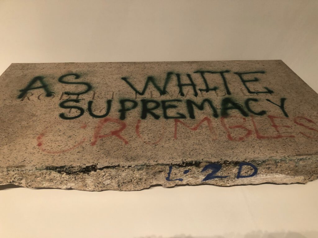 Piece of Robert E. Lee Memorial with graffiti that reads "As White Supremacy Crumbles" from Monuments at MOCA Geffen Contemporary (Photo: Liz Ohanesian)